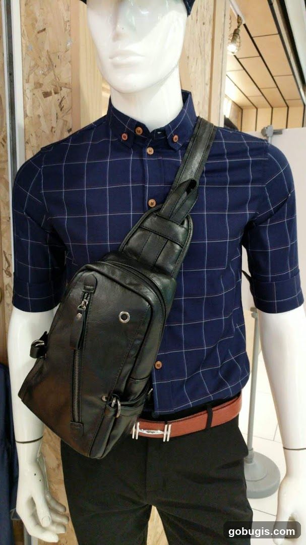 Mannequin wearing a plaid shirt and sling bag