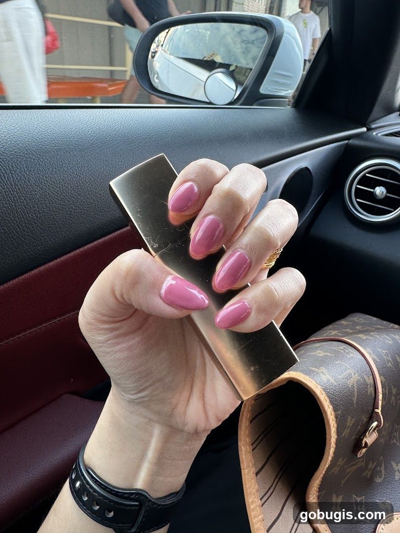 Woman holding a gold object with pink nails