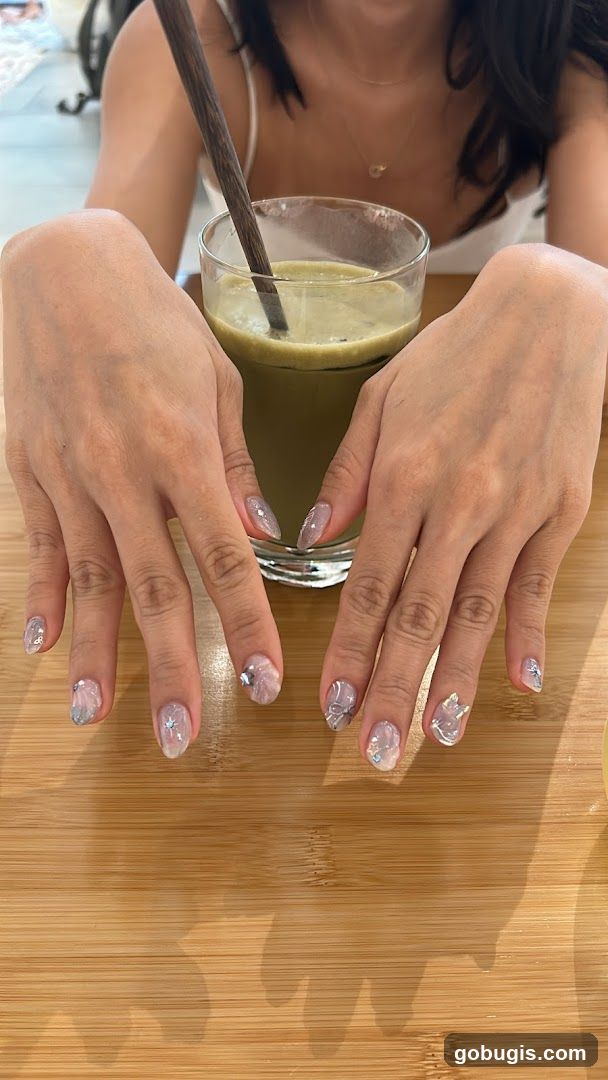 Woman with decorated nails and a drink