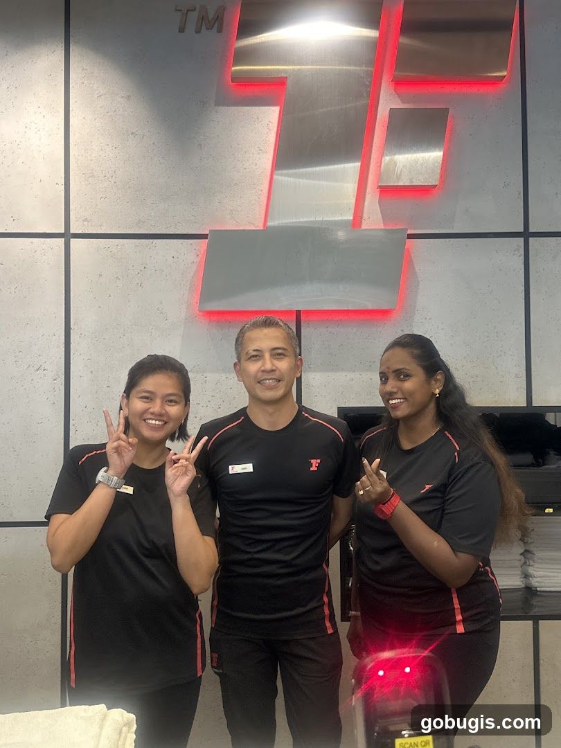Staff Posing in Front of Logo