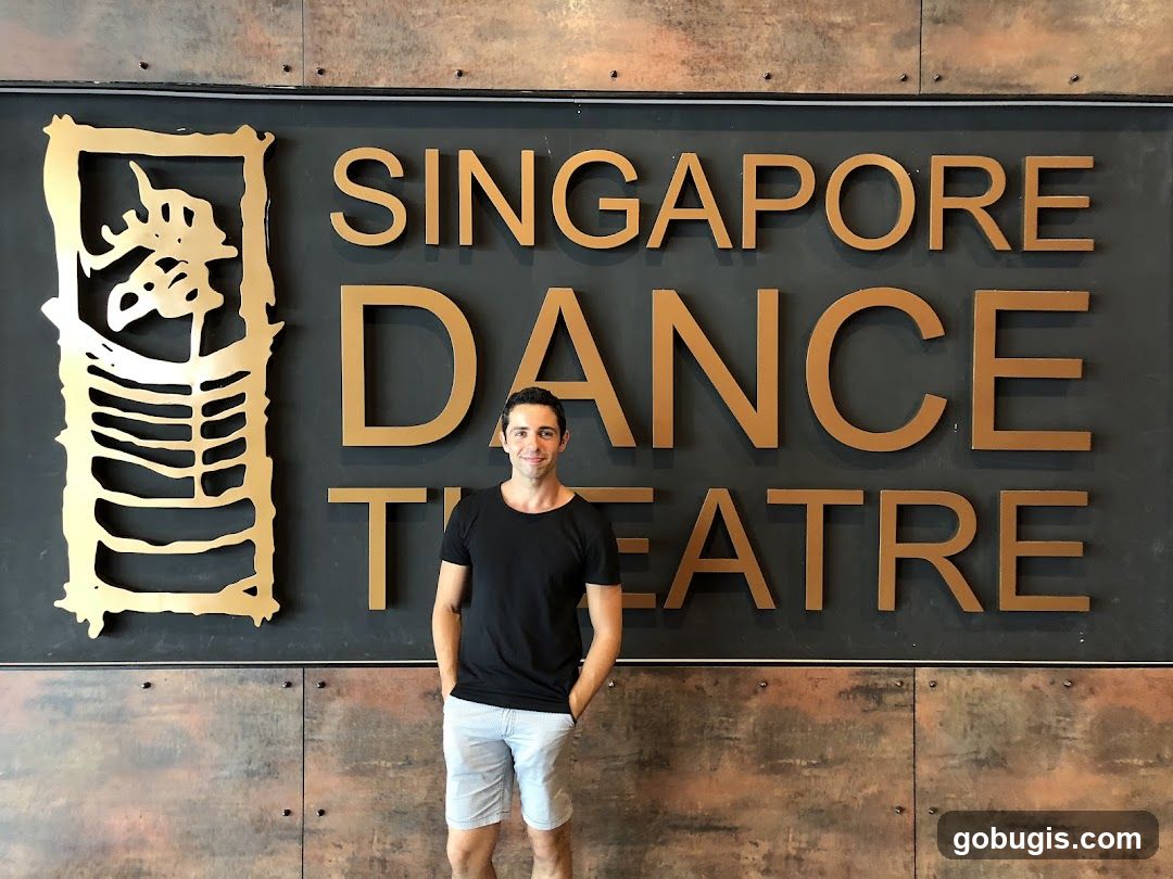 Man Poses in Front of Singapore Dance Theatre Sign