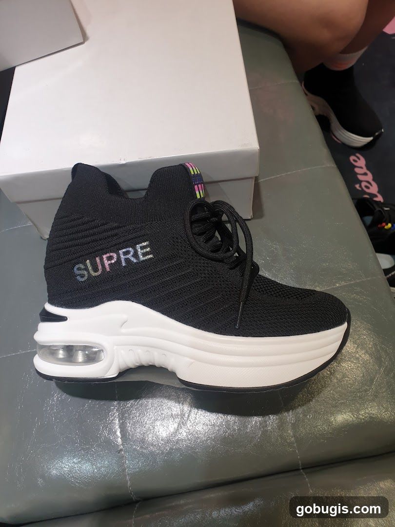 Black sneakers with "SUPRE" logo