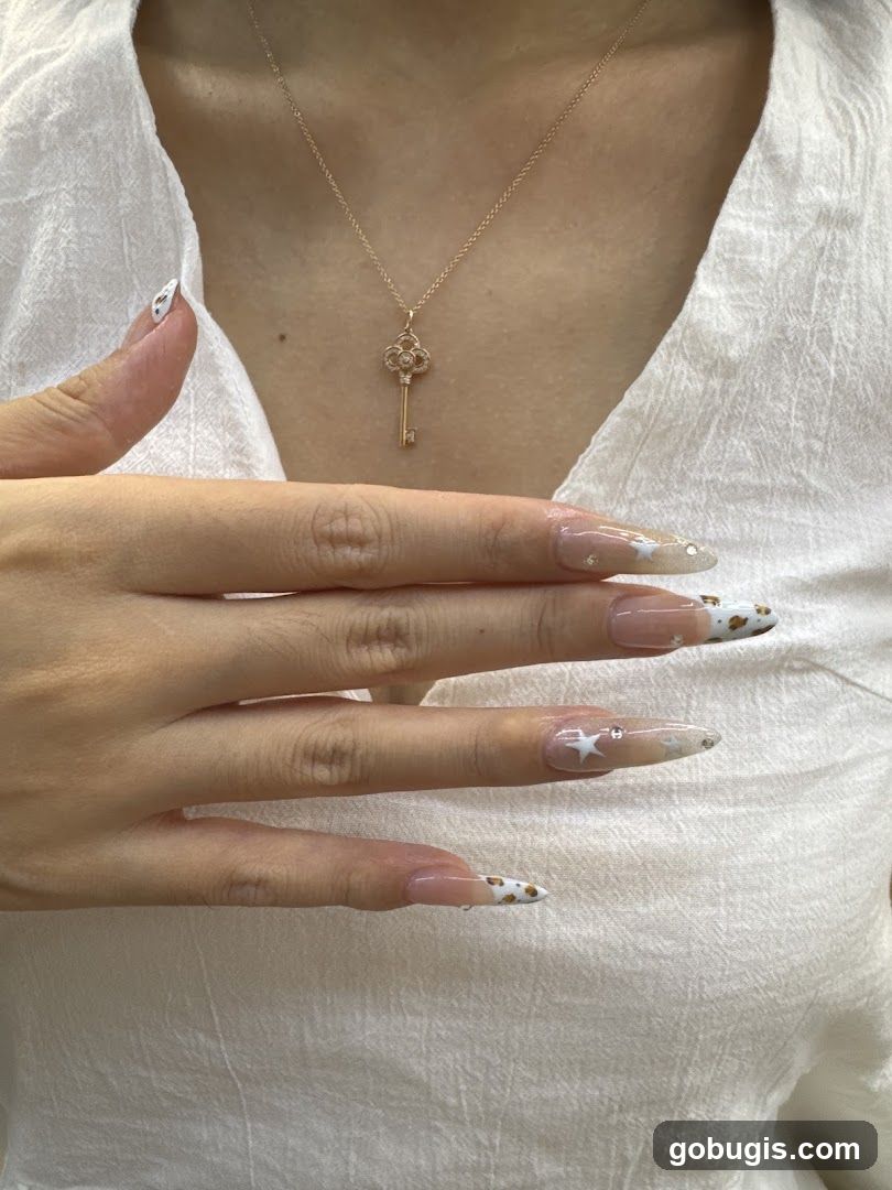 Woman wearing a key pendant necklace and showing off her decorated nails
