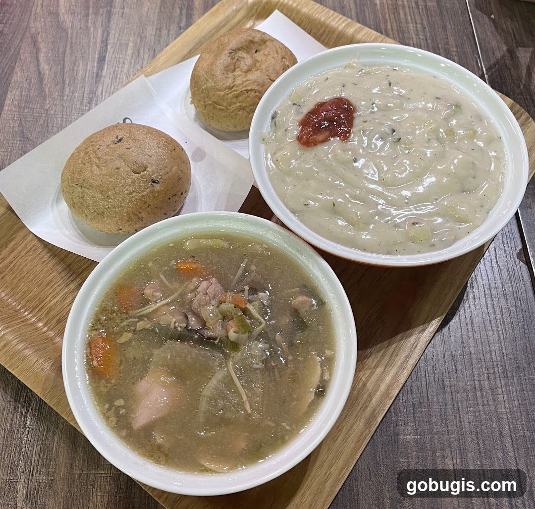 Two bowls of soup and bread rolls