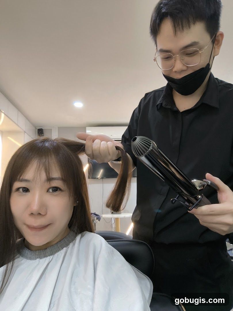 Hairdresser curling client's hair