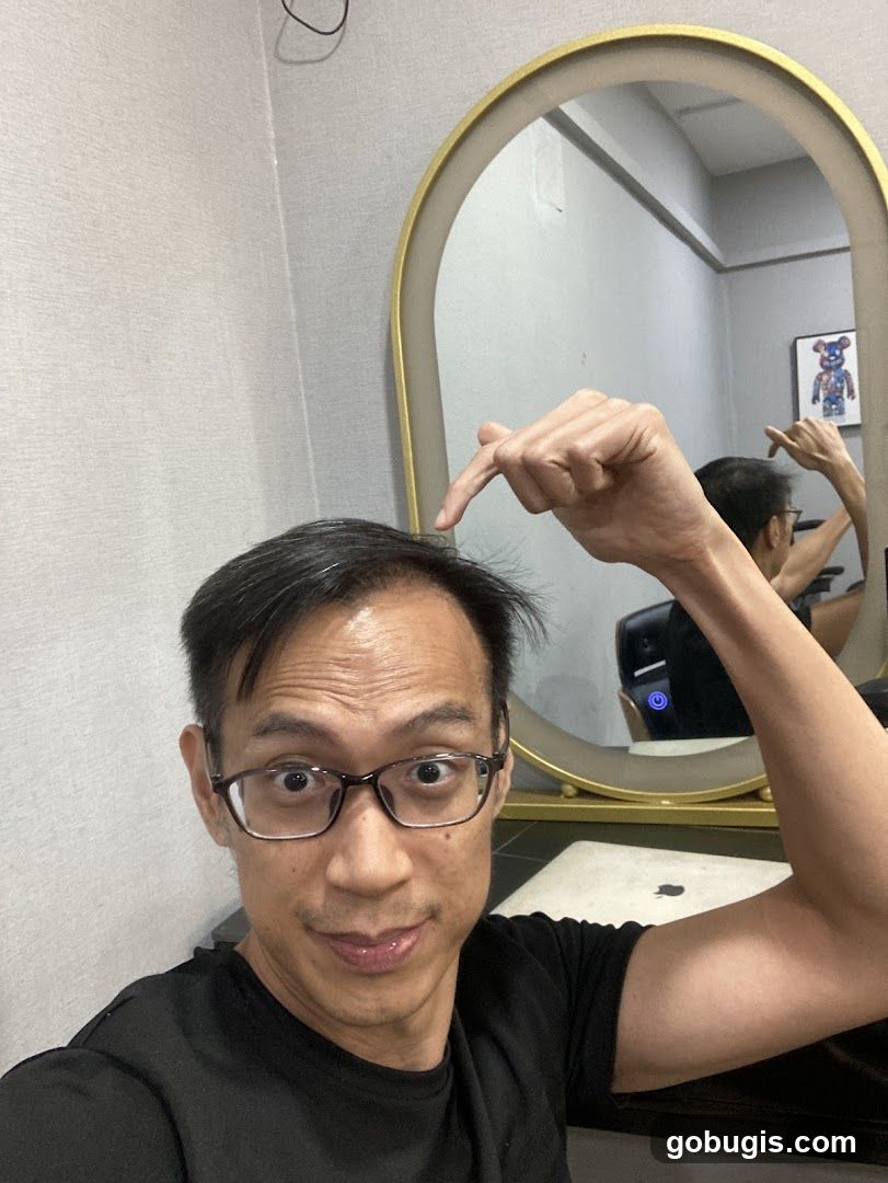 Man pointing at his hair in a mirror