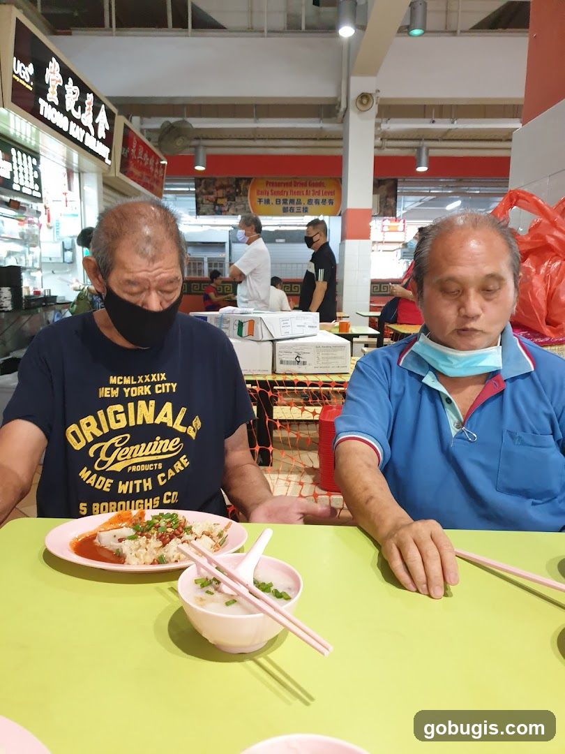 Two Men Eating at a Food Stall