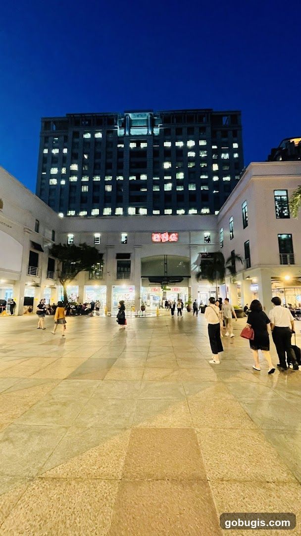 Outdoor plaza at night with a large building in the background