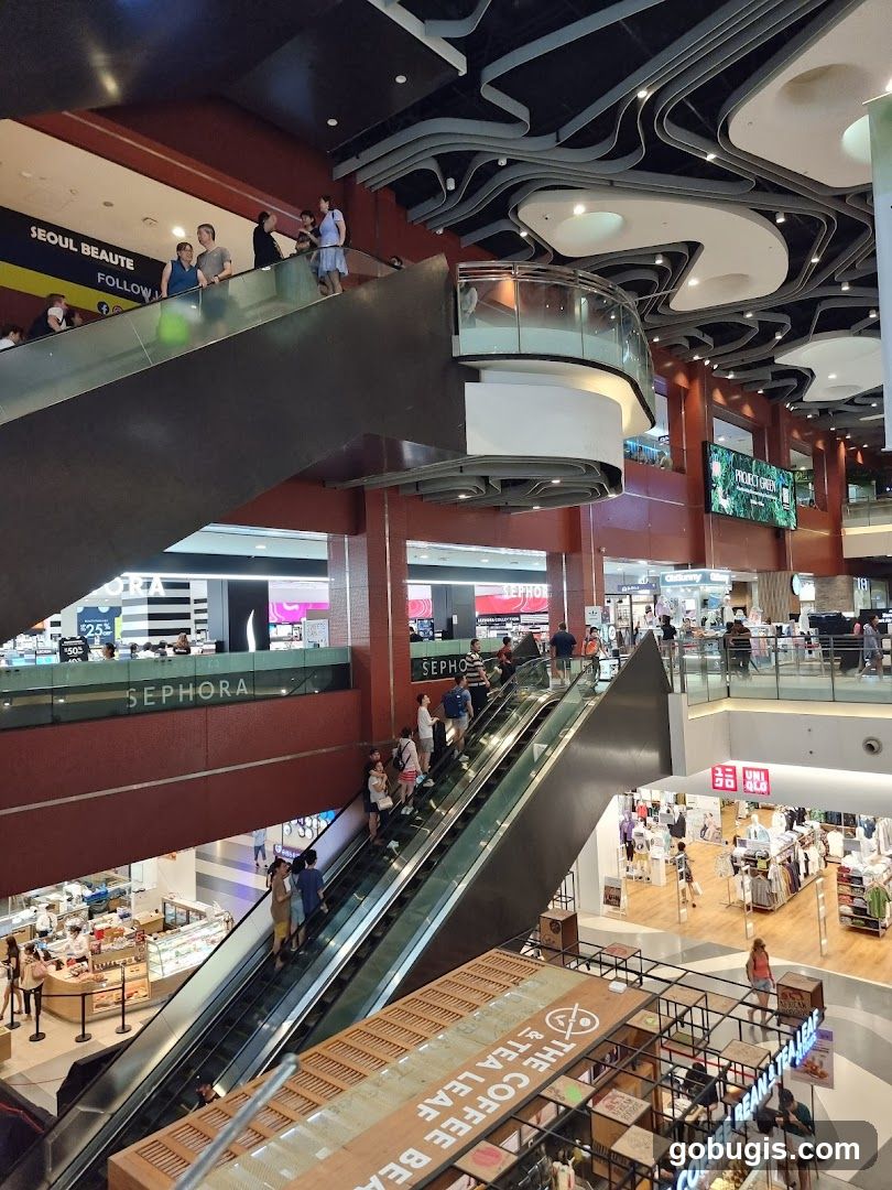 Busy shopping mall interior with escalators and shops