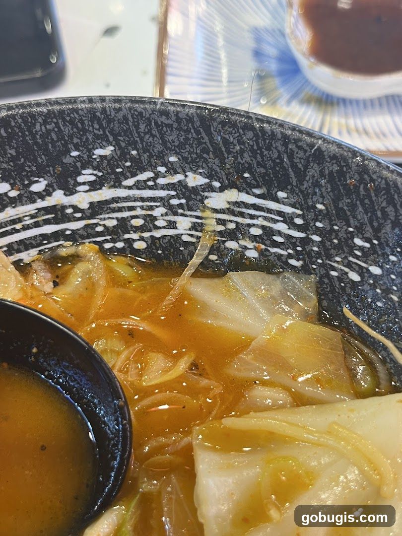 Bowl of noodles with cabbage and a spoon