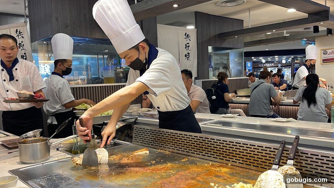Chefs preparing food at a teppanyaki grill