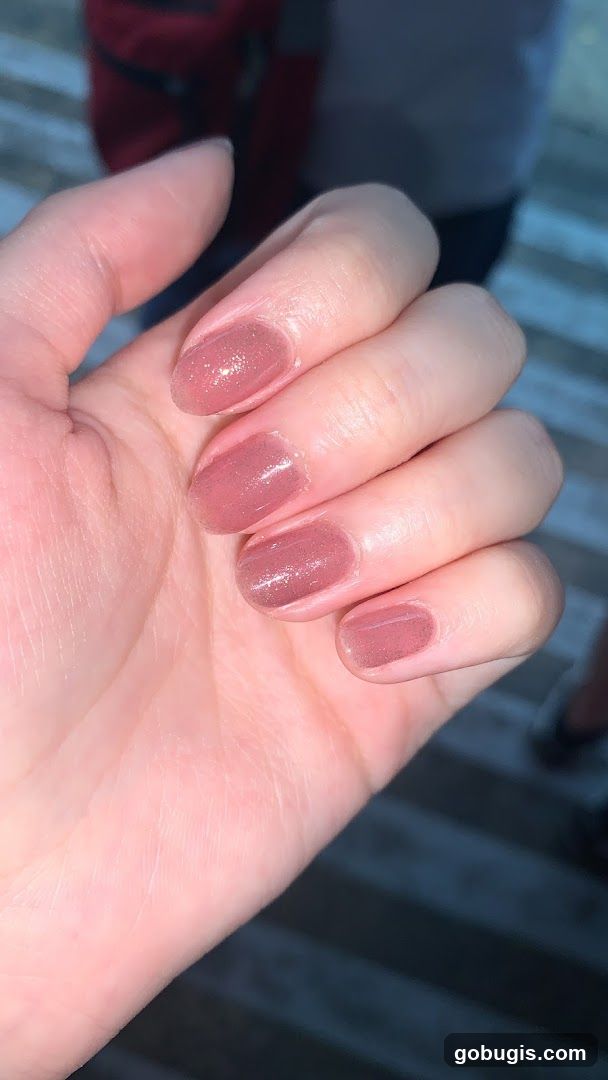 Close-up of a hand with pink glitter nail polish