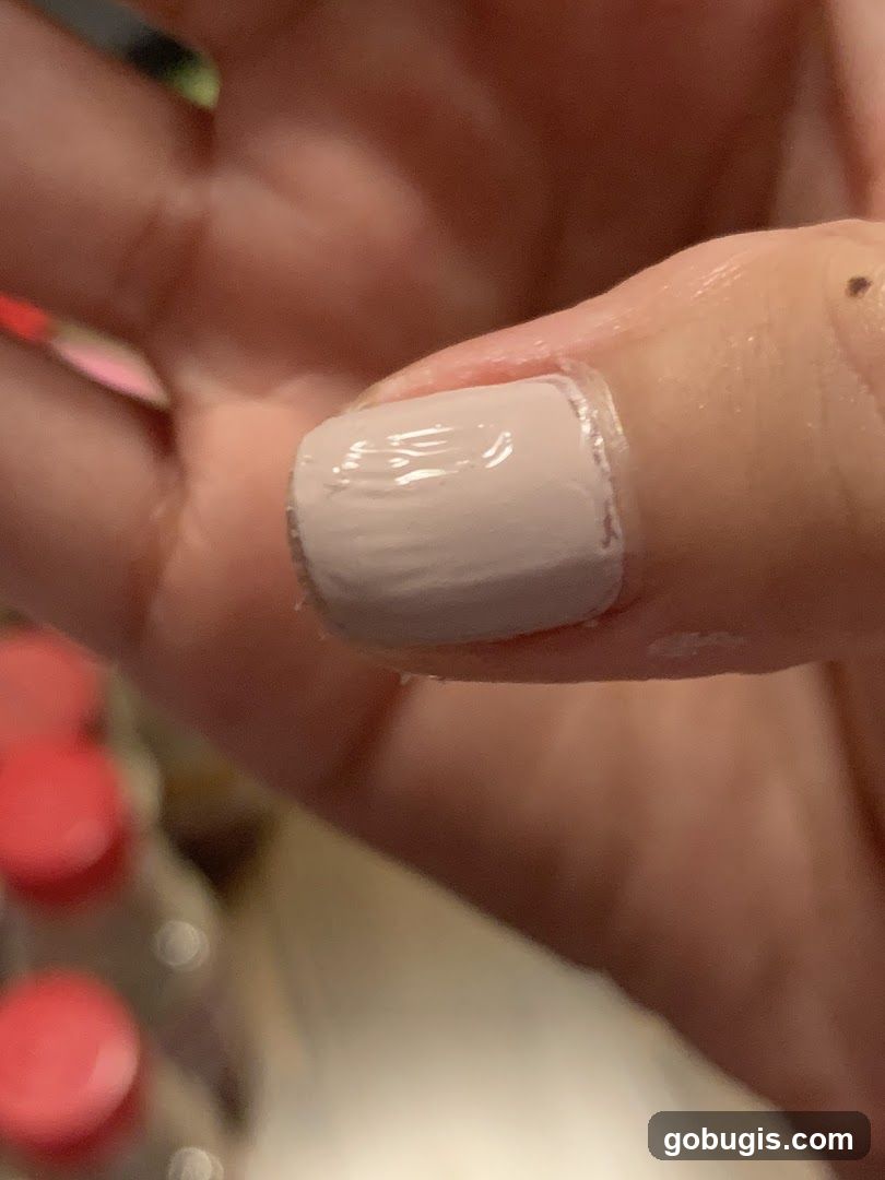 Close-up of a fingernail with light pink polish