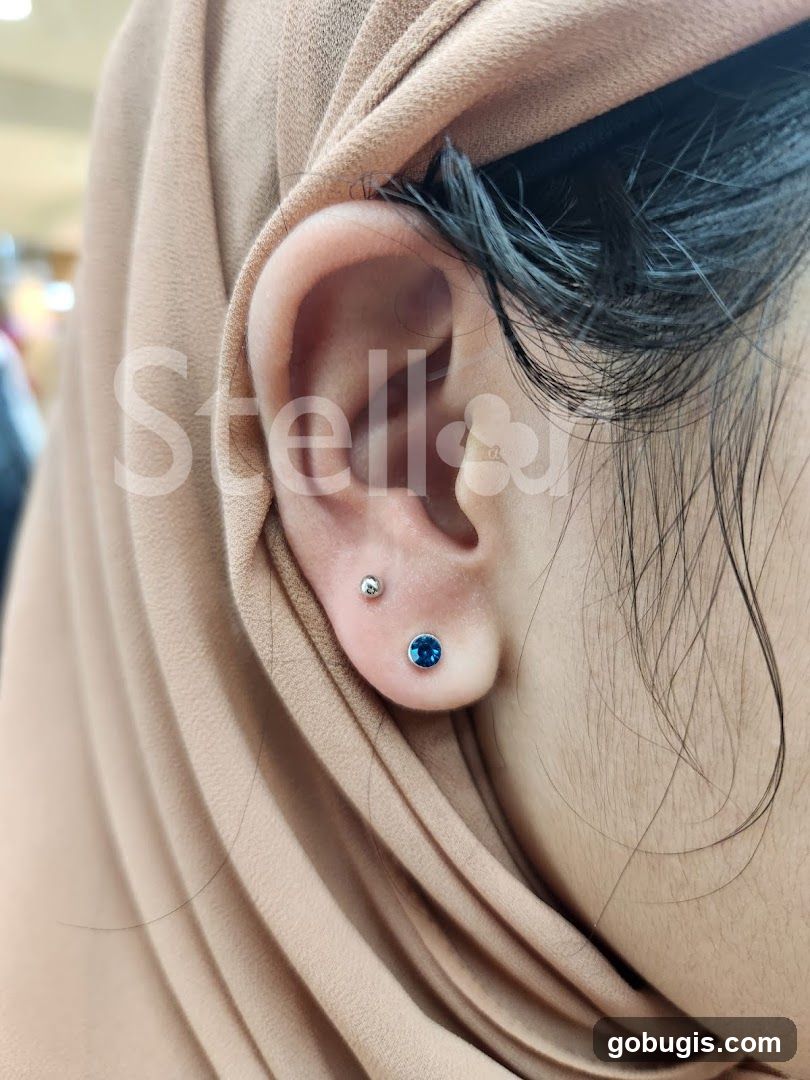 Close-up of a person's ear with two piercings