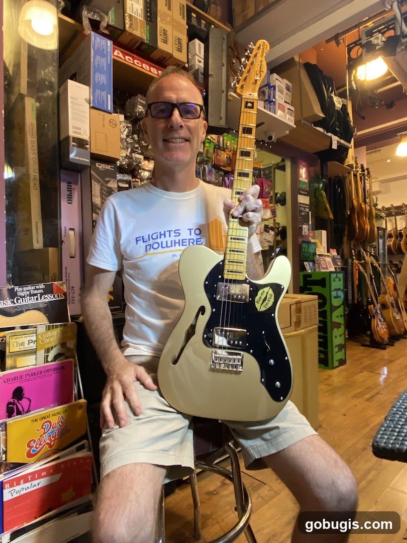 Man holding a guitar in a music shop