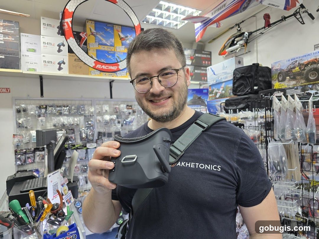 Man holding FPV goggles in a hobby shop