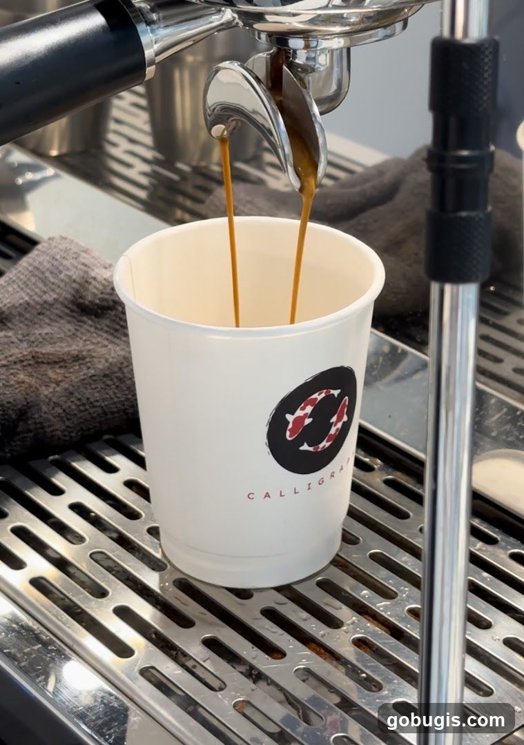Espresso Being Poured into a Branded Cup