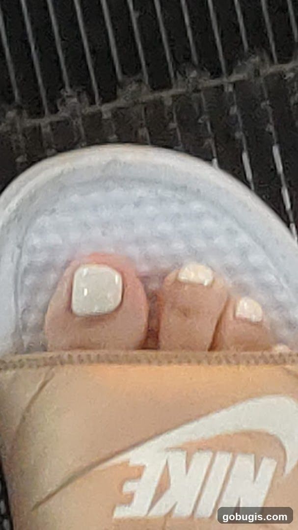 Toes with White Nail Polish in Slide Sandals