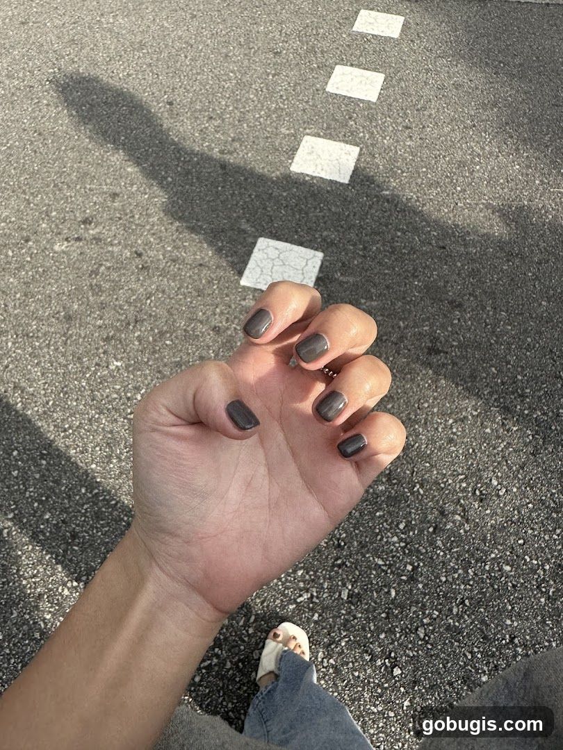 Hand with dark grey nail polish