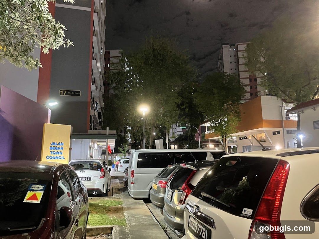 Street scene at night with parked cars and buildings