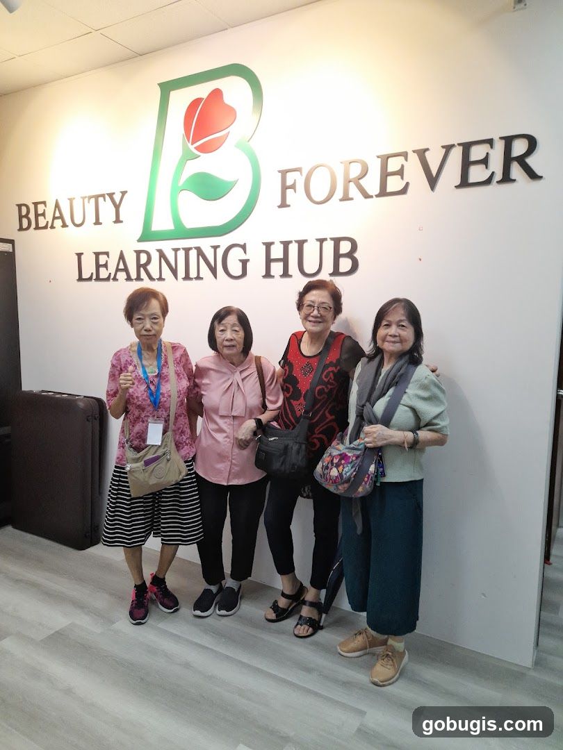 Four women posing in front of a wall with a logo and text
