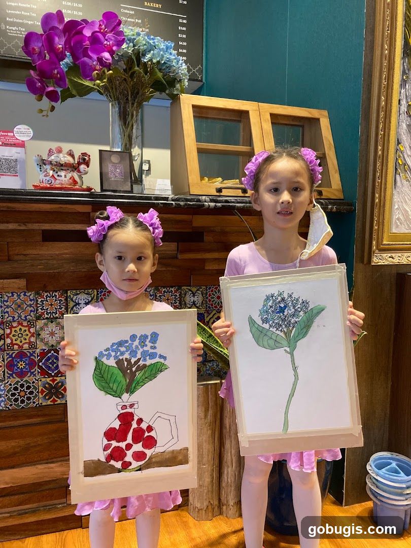 Two girls holding up their artwork