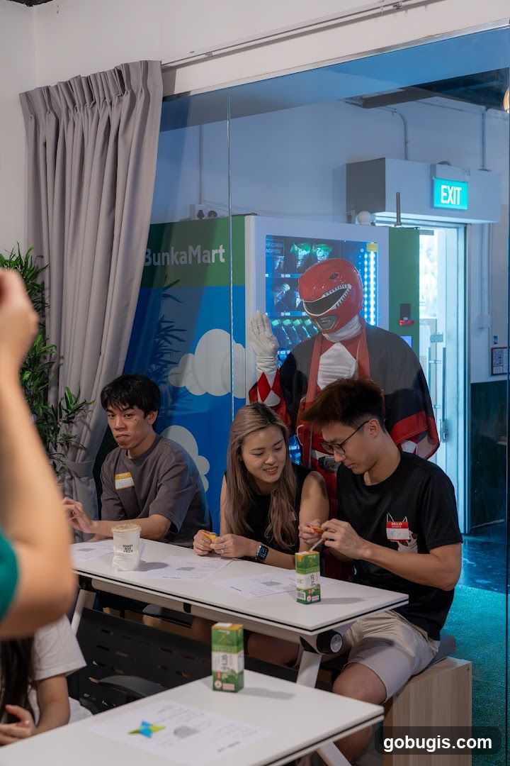People at a table with a Red Ranger mascot