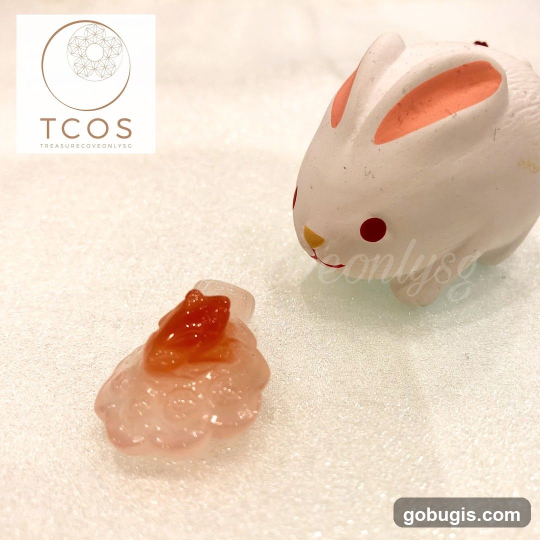 White ceramic bunny figurine and pink crystal charm