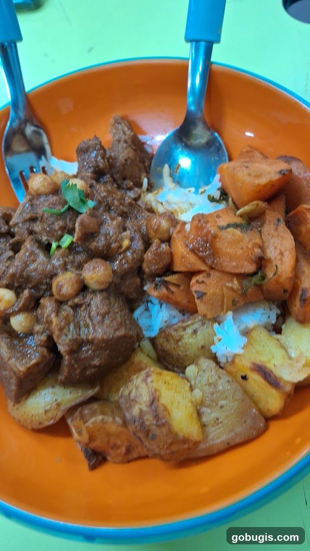 Bowl of food with meat, rice, and vegetables