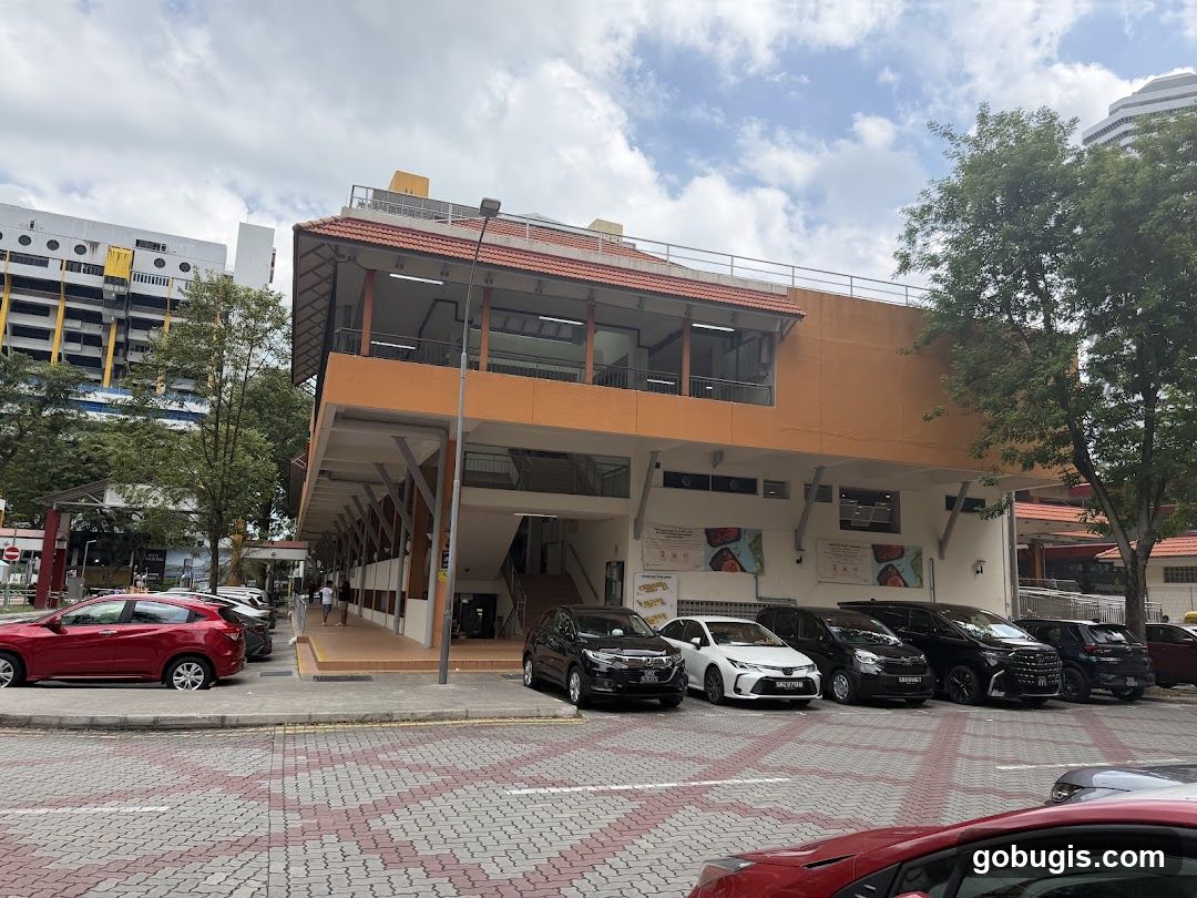 Outdoor view of a building with shops and parking