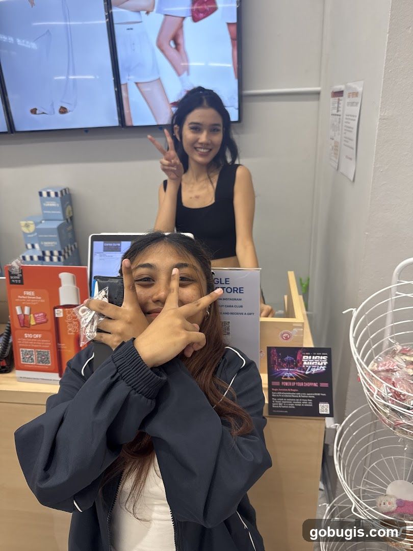 Two young women posing for a photo at a store counter