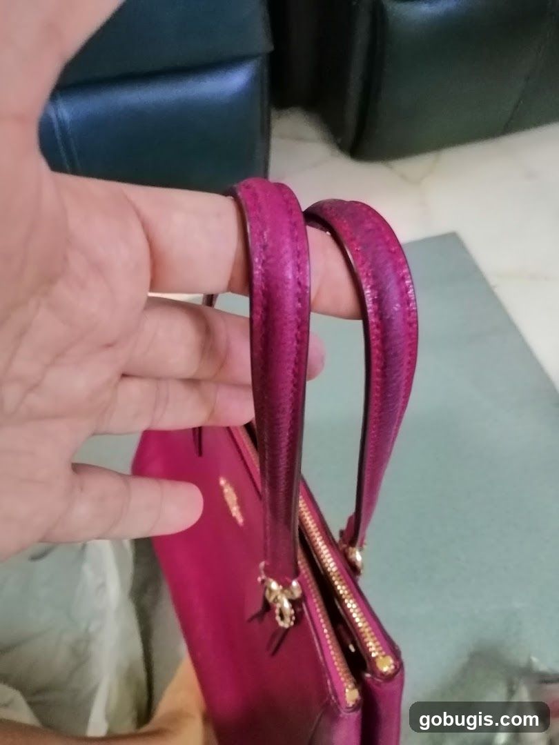 Hand holding a pink handbag