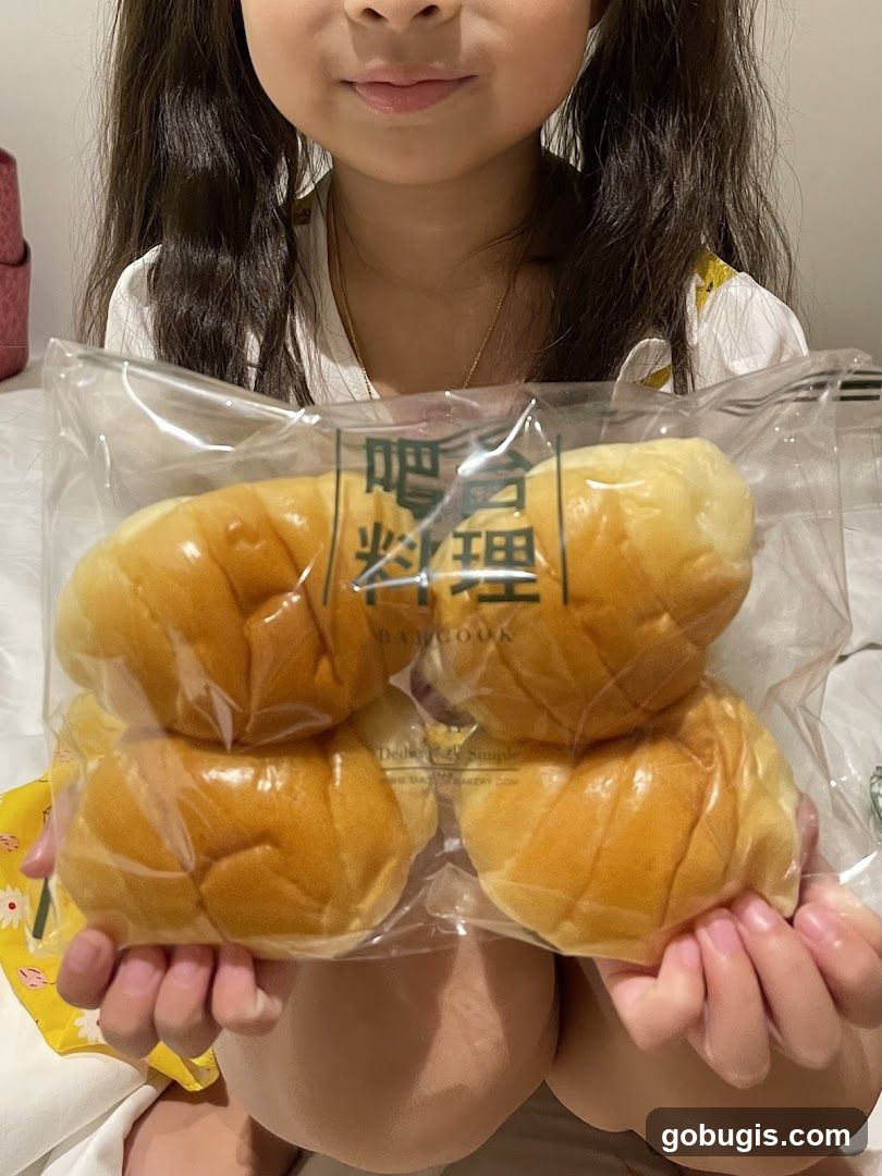 Child holding a bag of bread rolls