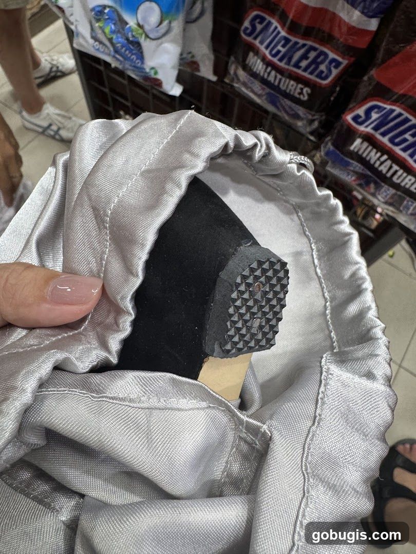 Close-up of a shoe heel inside a silver drawstring bag
