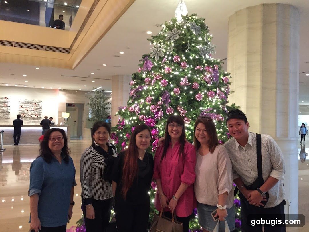 Group posing in front of a Christmas tree