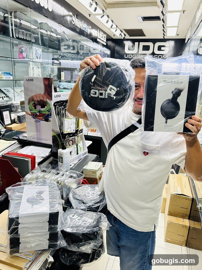 Man holding DJ accessories in a store