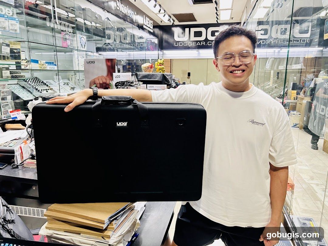 Man holding a black UDG gear bag