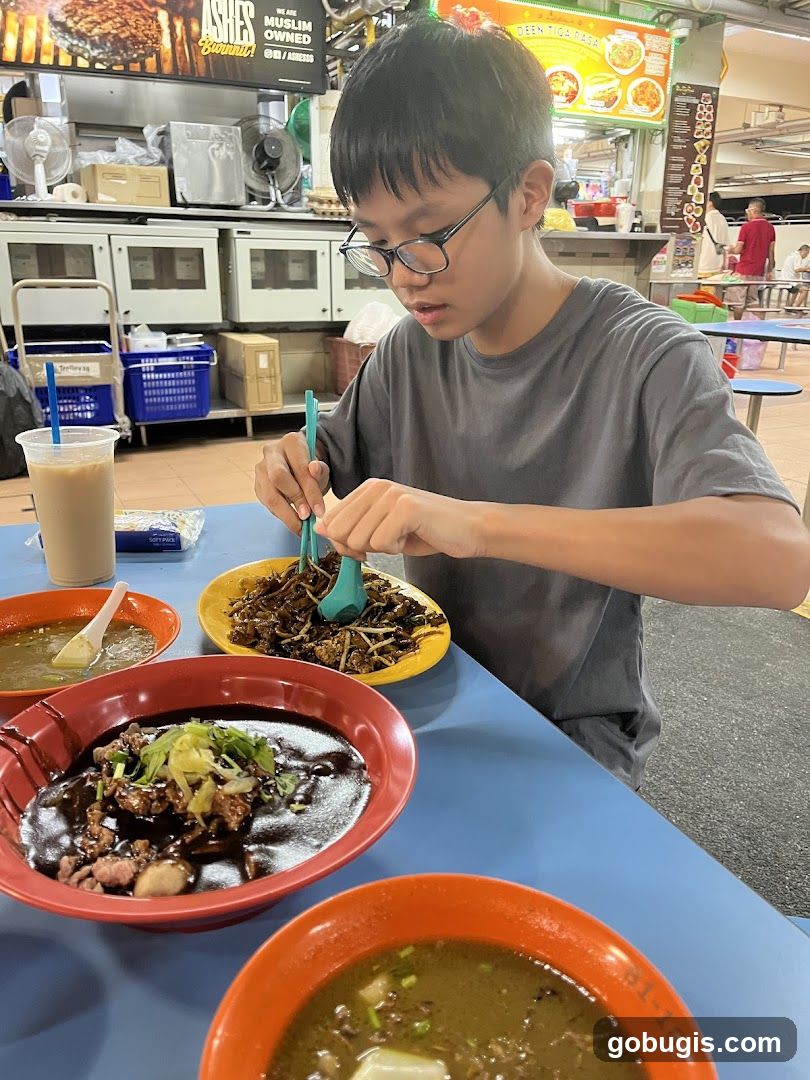 Boy eating noodles at a food stall