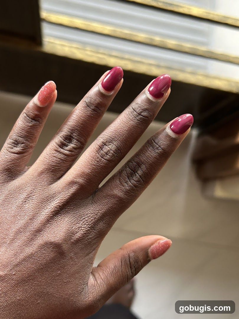 Woman's Hand with Burgundy and Glitter Nail Polish
