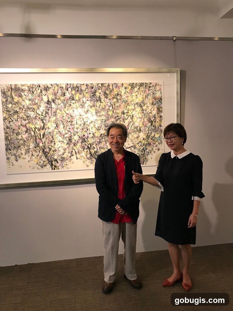 Two people posing in front of a painting