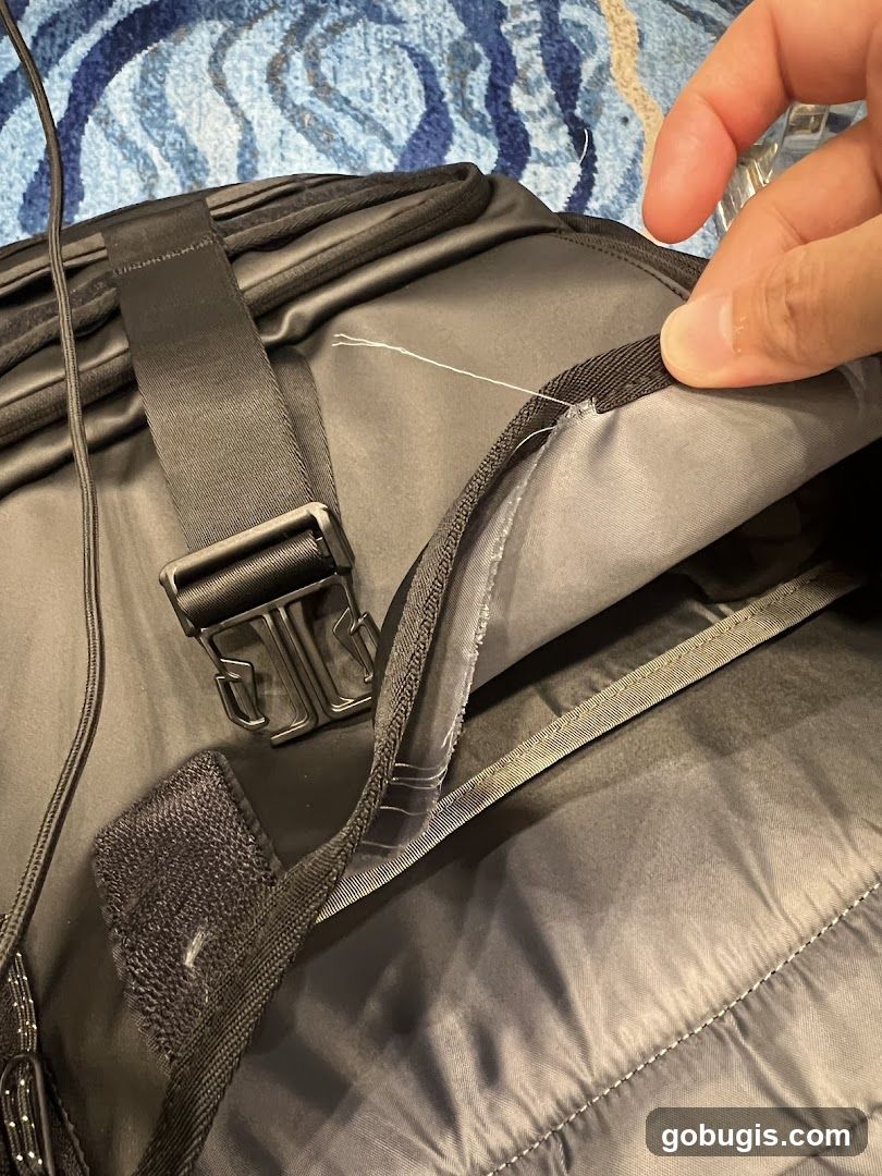 Close-up of a black backpack with loose threads