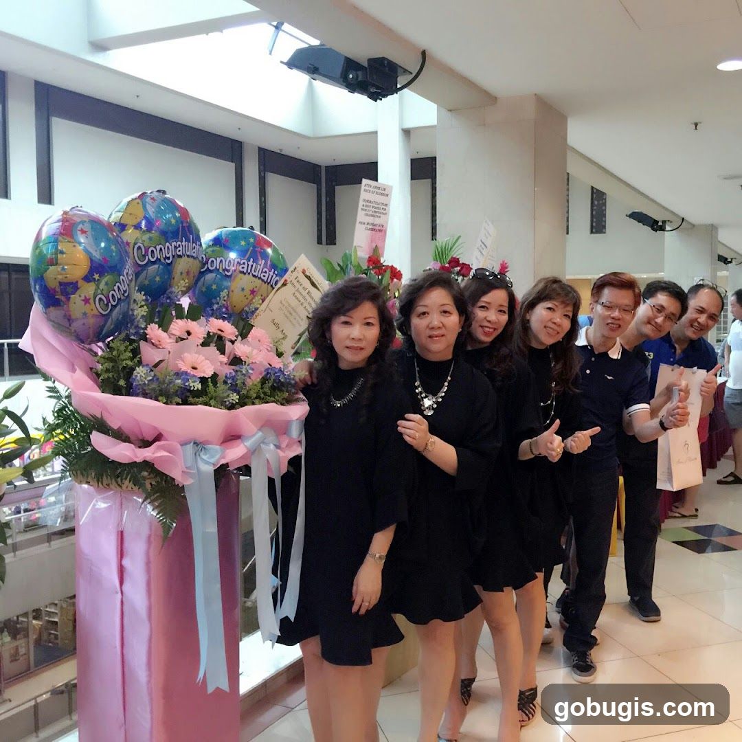Group Posing with Congratulatory Balloons and Flowers