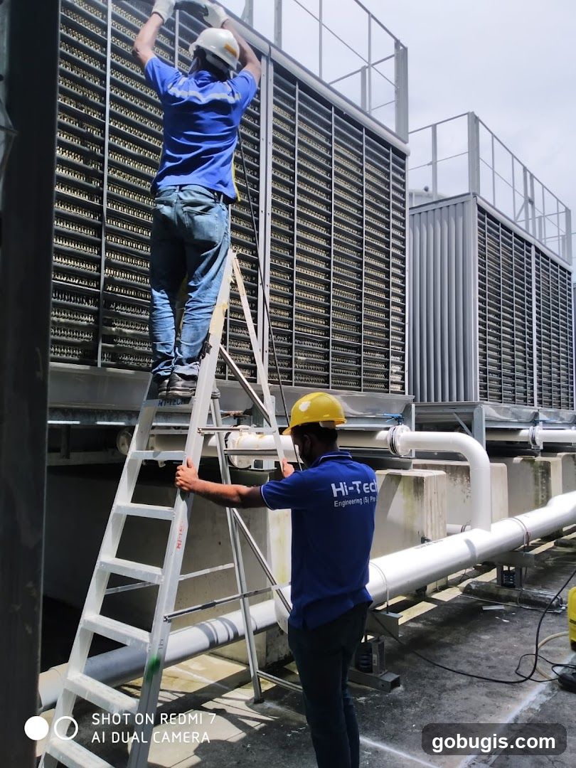 Workers maintaining industrial cooling units