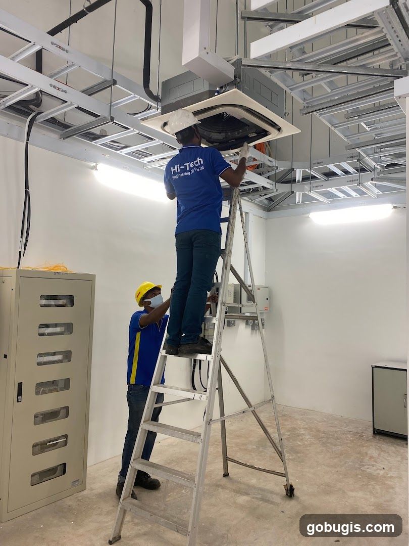 Technicians installing ceiling unit