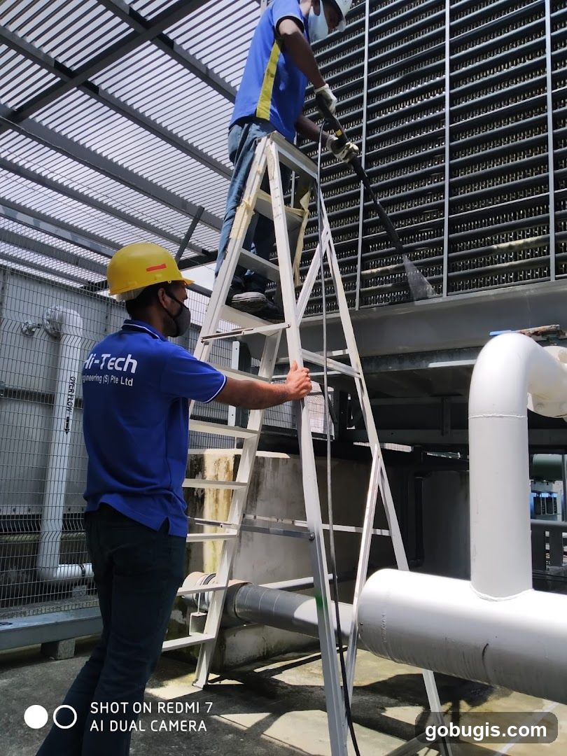 Workers cleaning industrial equipment