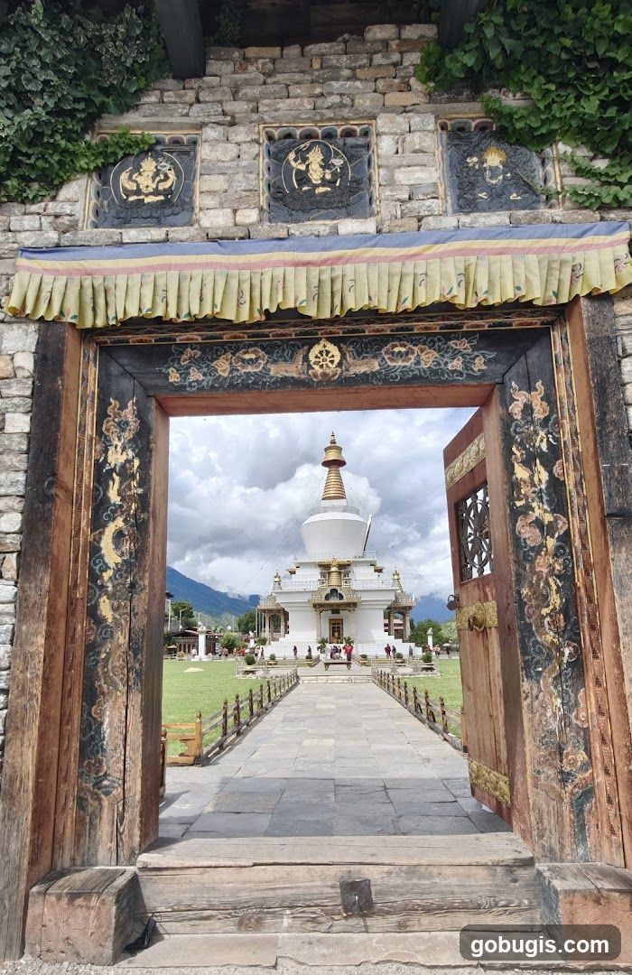 View of a stupa through a decorated doorway