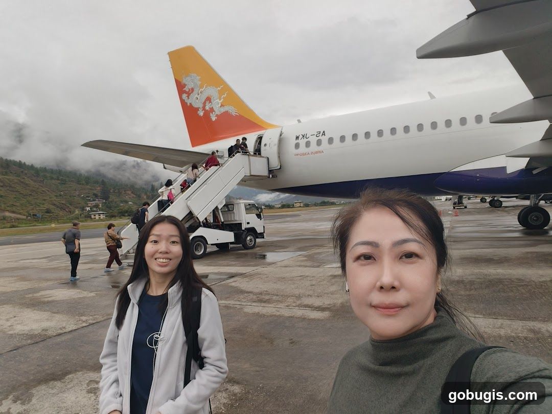 Two Women on Airport Tarmac with Airplane