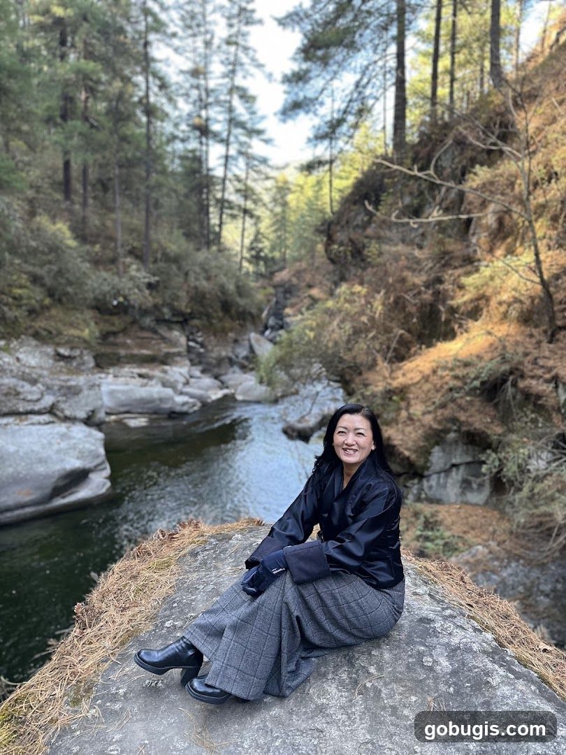 Woman sitting by a river in a forest