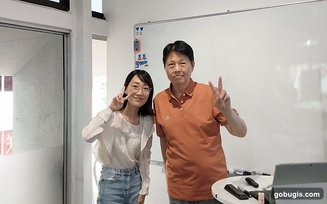 Two people posing in front of a whiteboard
