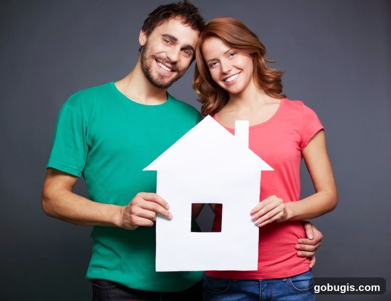 Couple holding a house cutout
